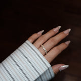 Hand with LUME dues gold ring on a dark background