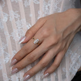 Hand wearing a diamond ring on a lace fabric background
