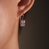 Close-up of a diamond earring on an ear with a dark background